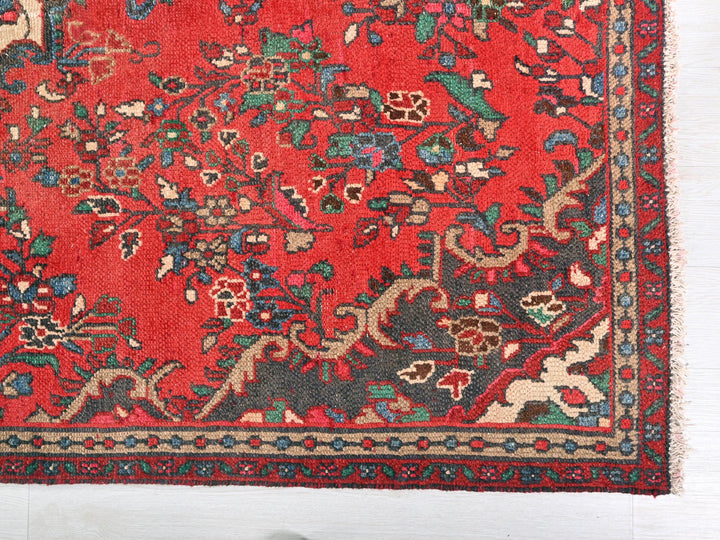 a red rug with a floral design on it