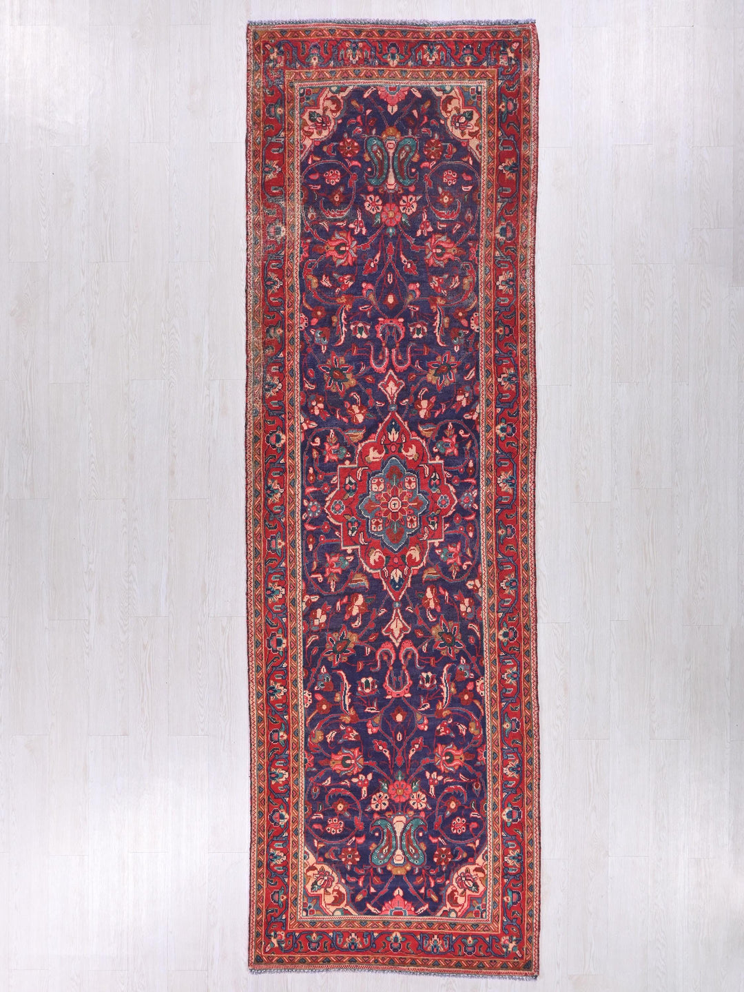 a red and blue rug hanging on a wall