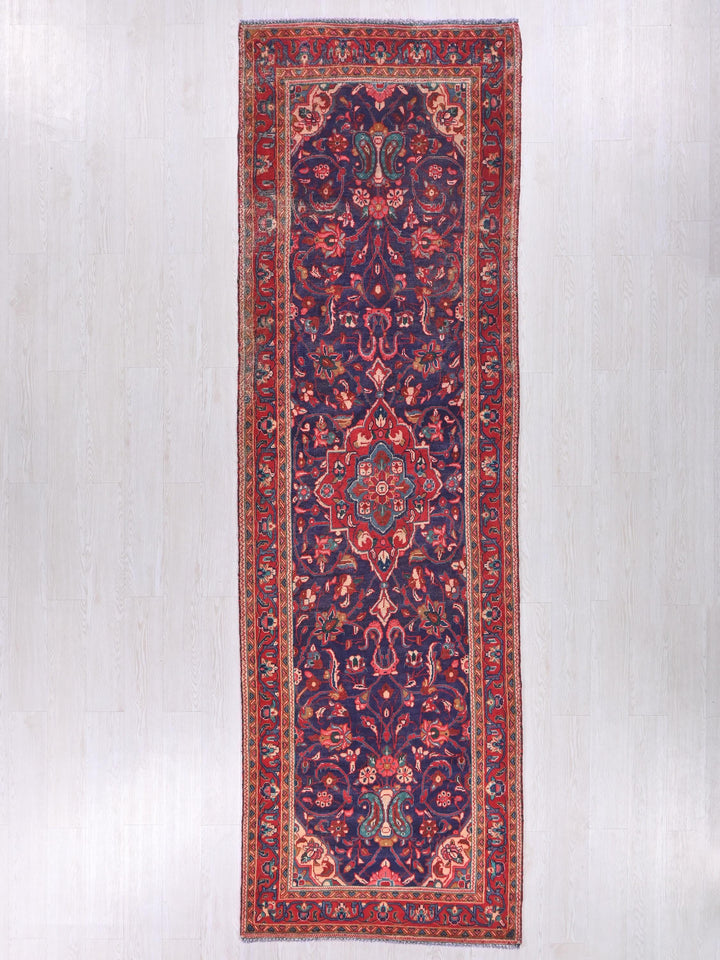 a red and blue rug hanging on a wall