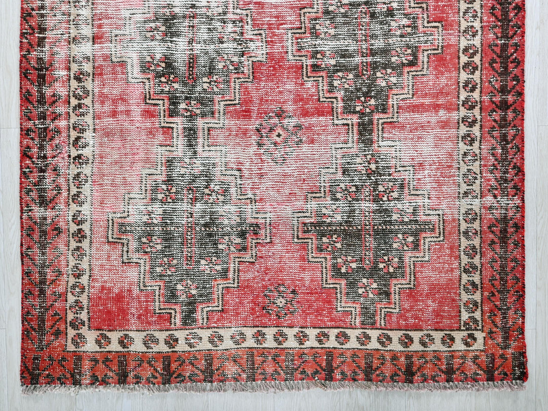 a red rug with a black and white design on it