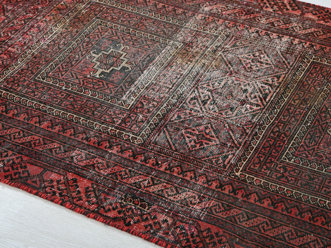 a red and black oriental rug on a white floor