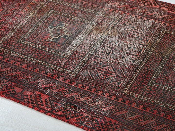 a red and black oriental rug on a white floor