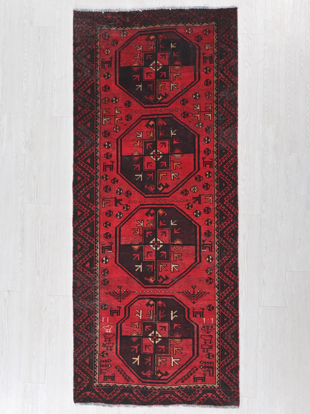 a red and black rug on a white floor