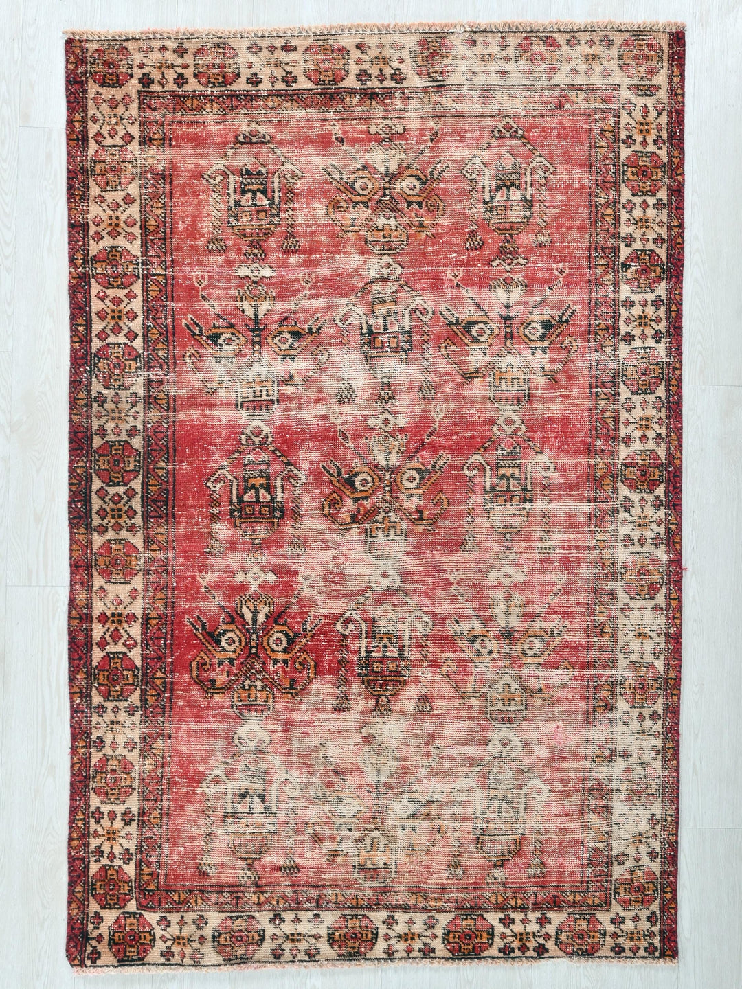 a red and beige rug on a white floor