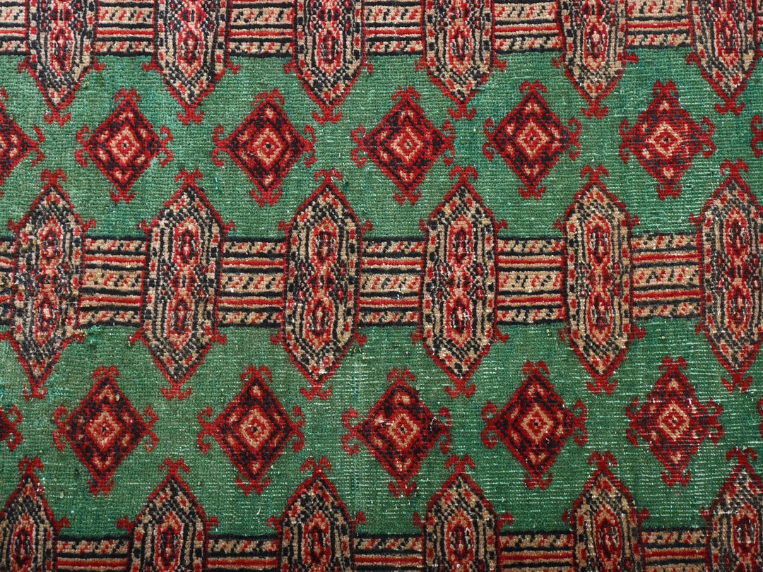 a close up of a green and red rug