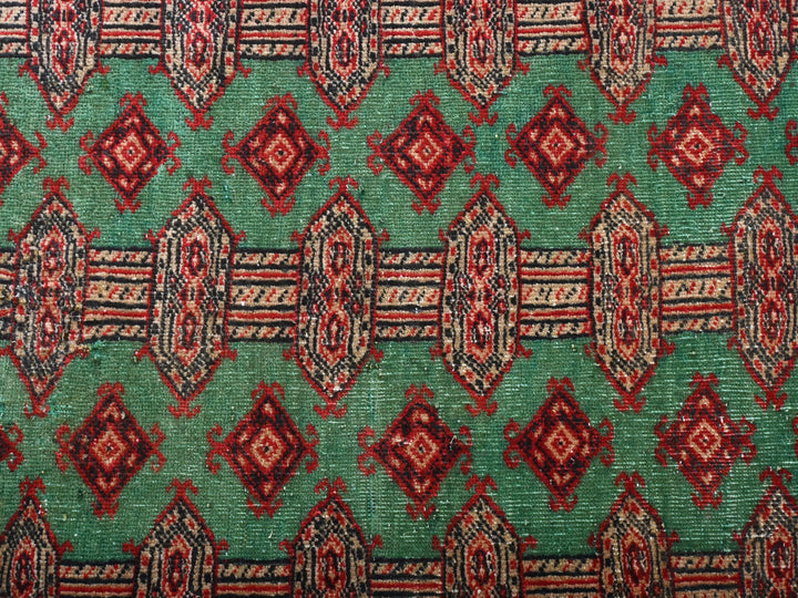 a close up of a green and red rug