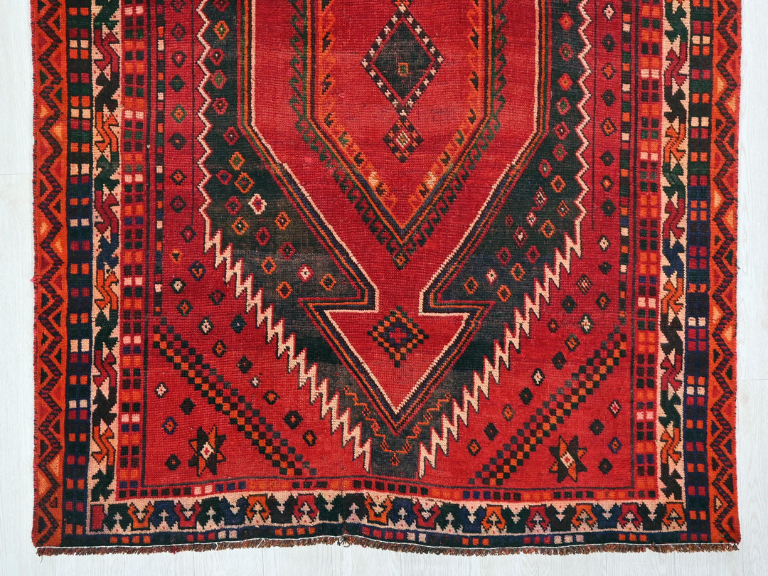 a red rug with a design on the middle of it