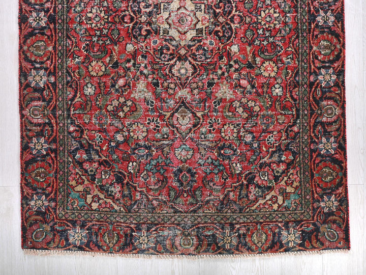 a red rug with a floral design on it