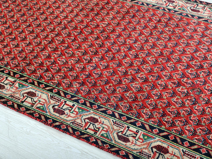a red and blue rug on a white floor