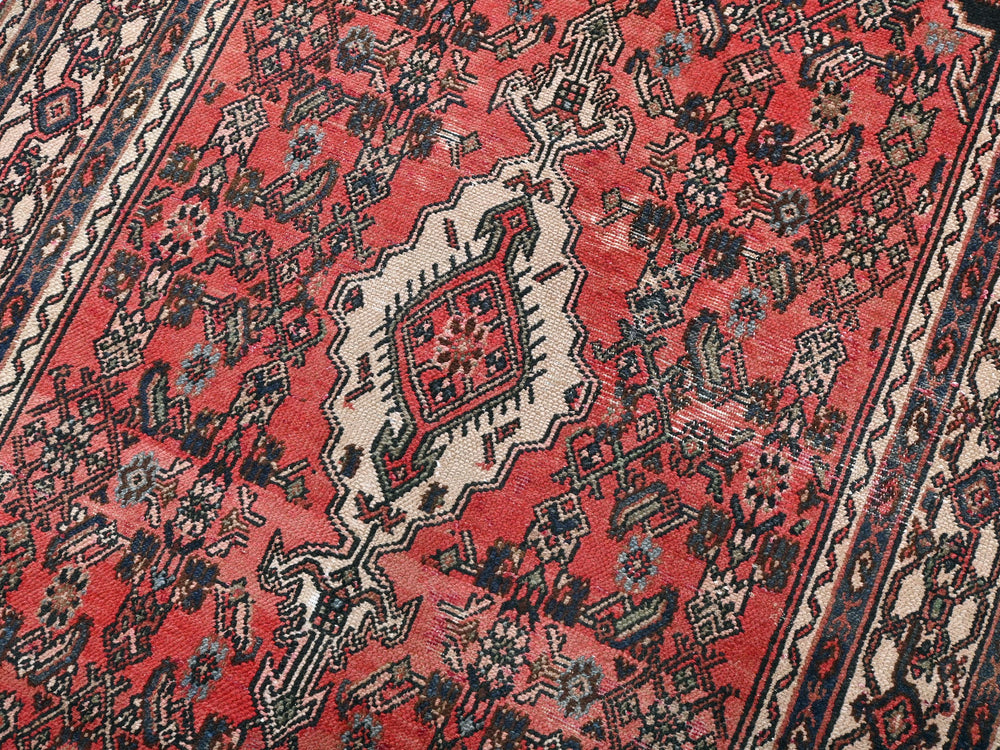 a red oriental rug with a blue border