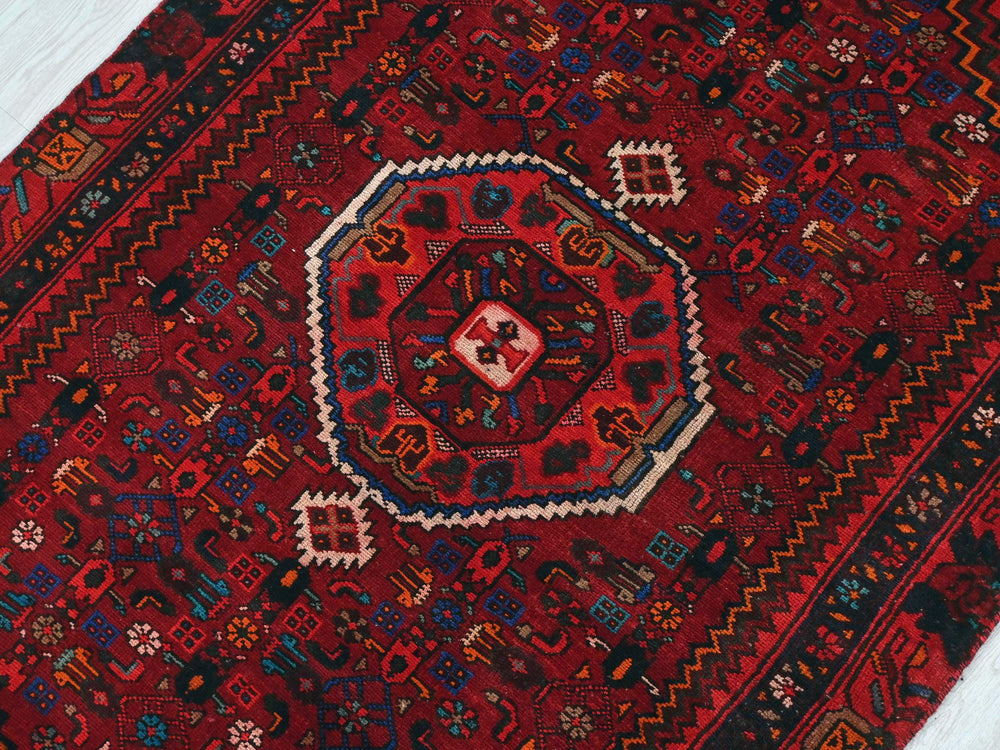 a red oriental rug on a white floor