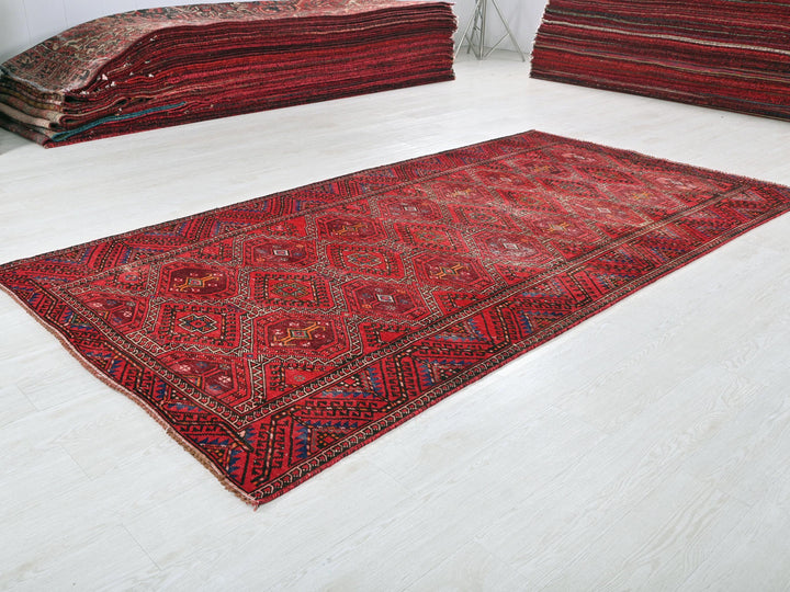 a pile of red rugs sitting on top of a white floor