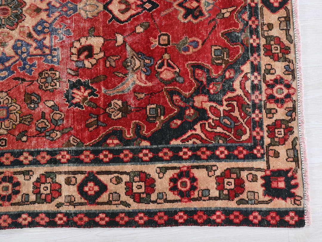 a red rug with a blue border on a white surface