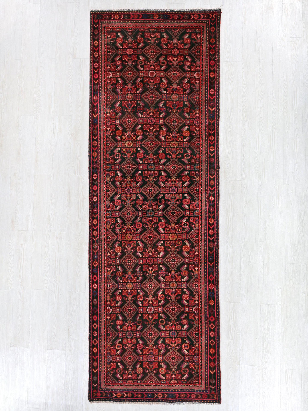 a red and black rug hanging on a wall