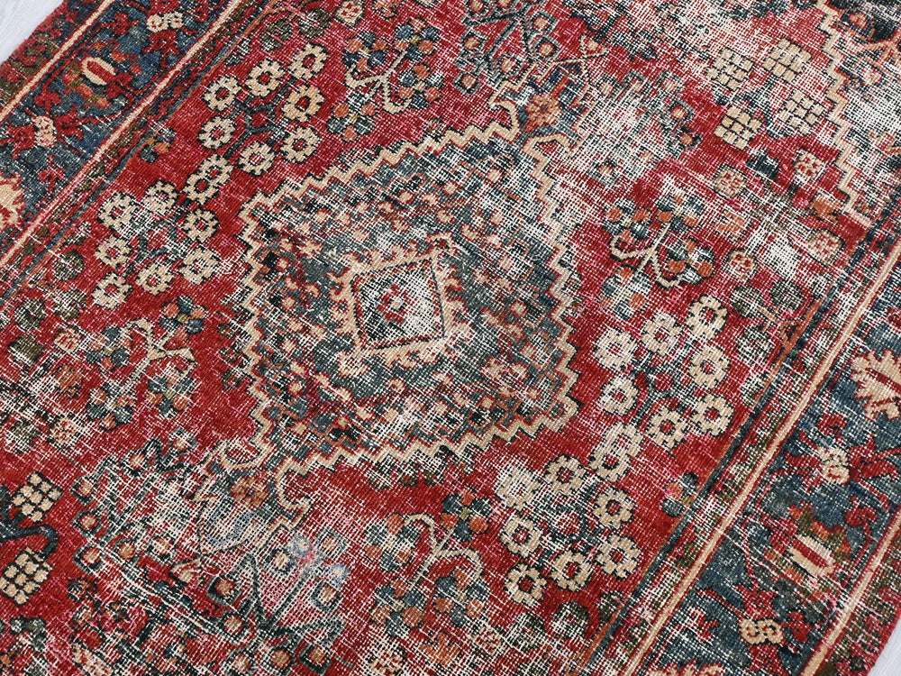 a red and blue oriental rug on a white floor