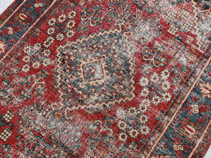 a red and blue oriental rug on a white floor