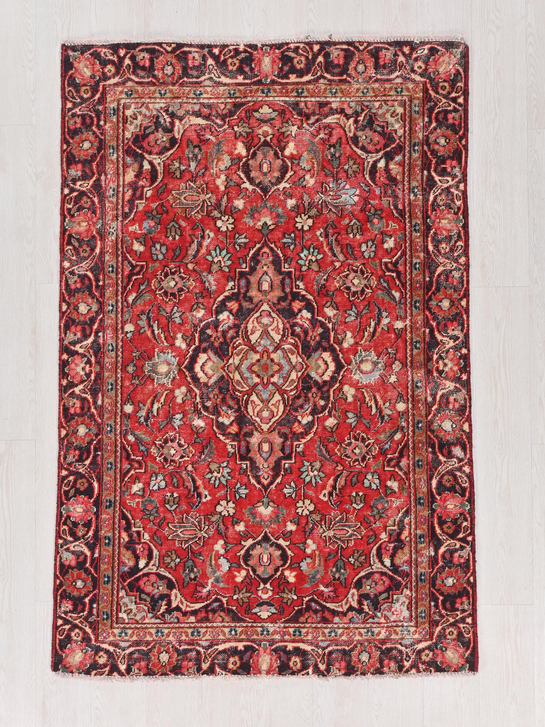 a red rug with a floral design on it