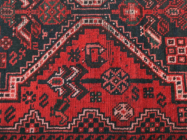 a close up of a red and black oriental rug