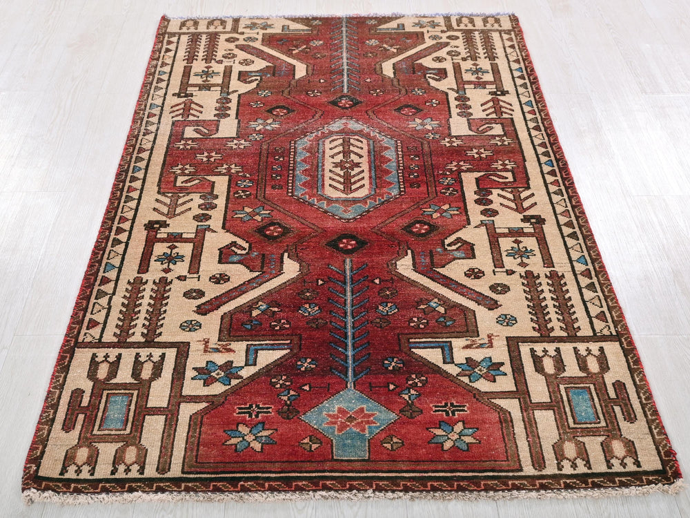 a red rug with a design on the middle of it