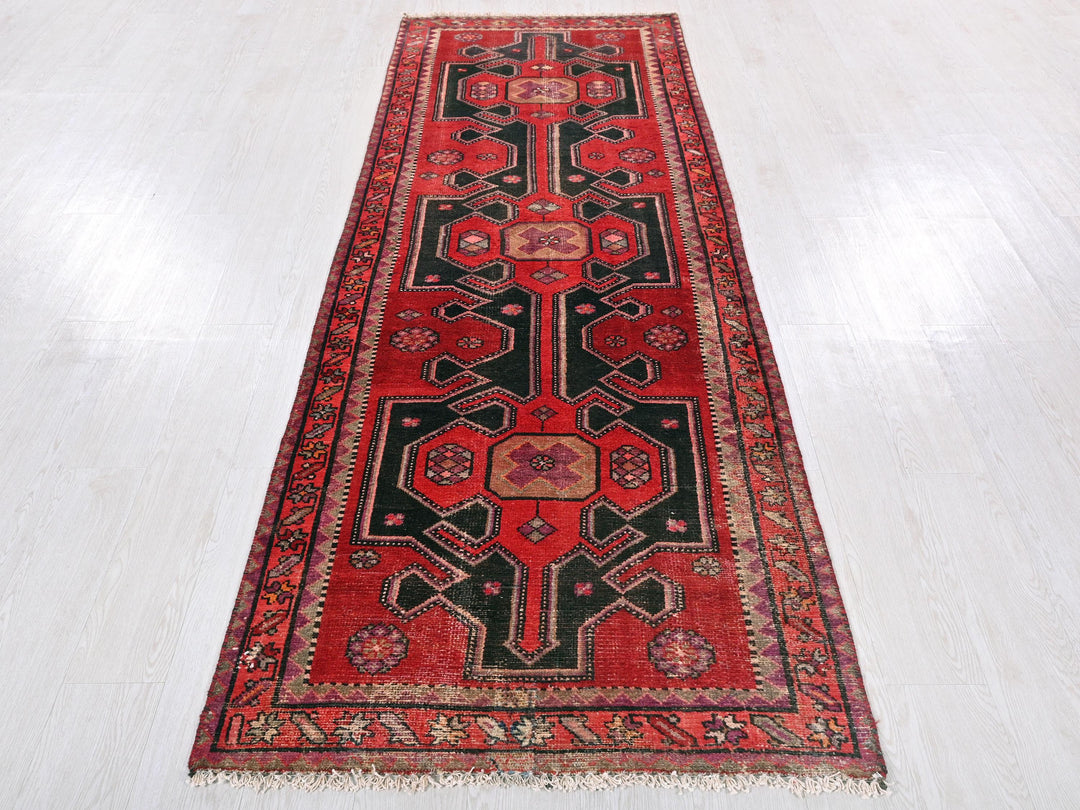 a red and black rug on a white floor
