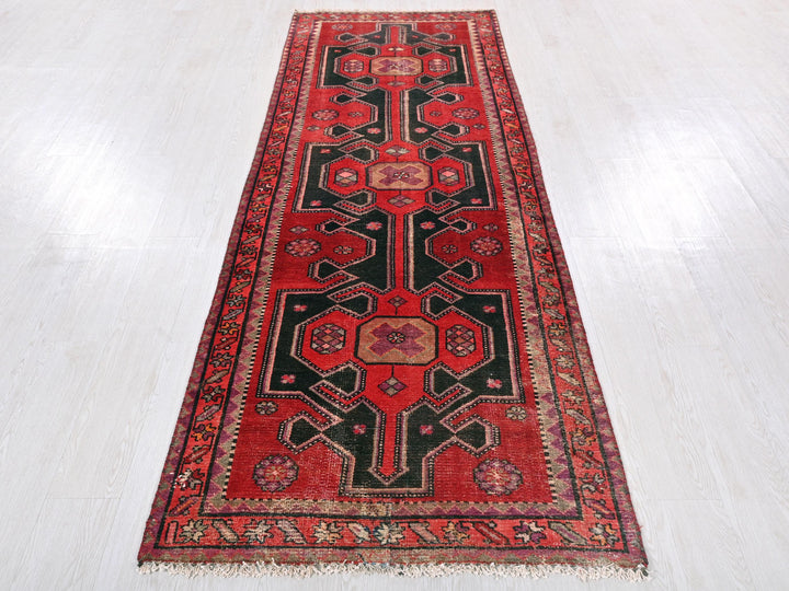 a red and black rug on a white floor