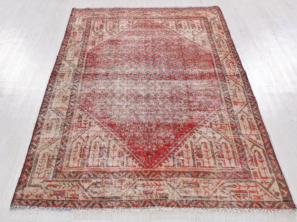 a red and beige rug on a white floor