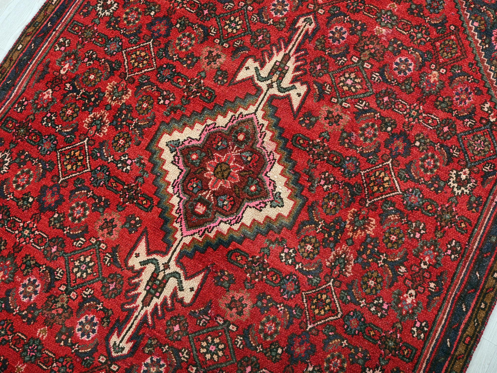a red oriental rug with an intricate design