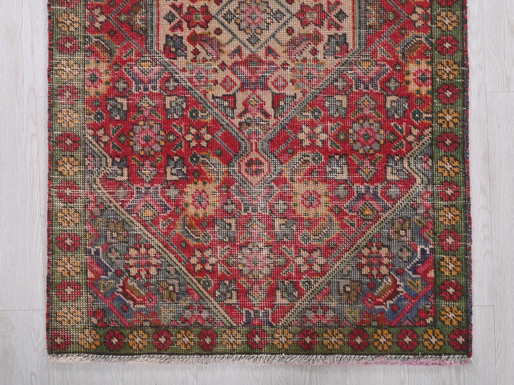 a red and green rug on a wooden floor
