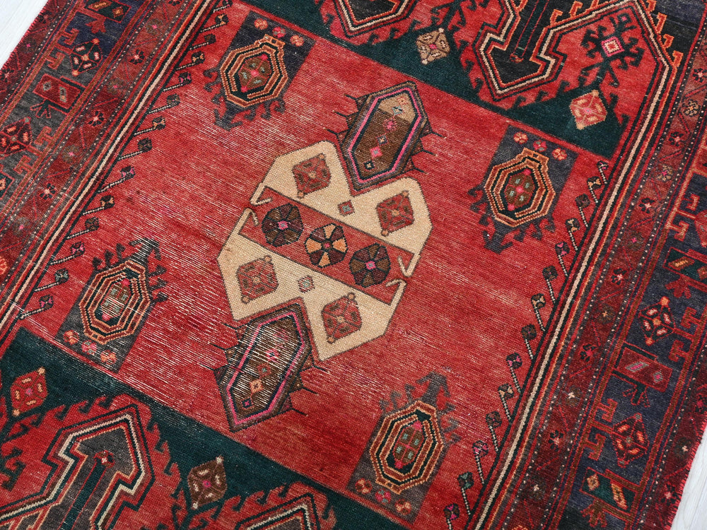 a red rug with a design on the middle of it