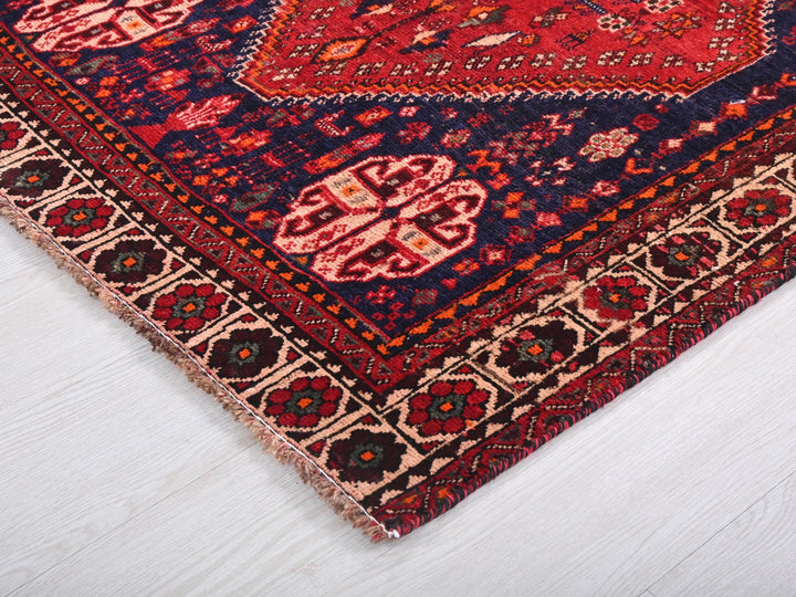 a red and blue oriental rug on a white floor