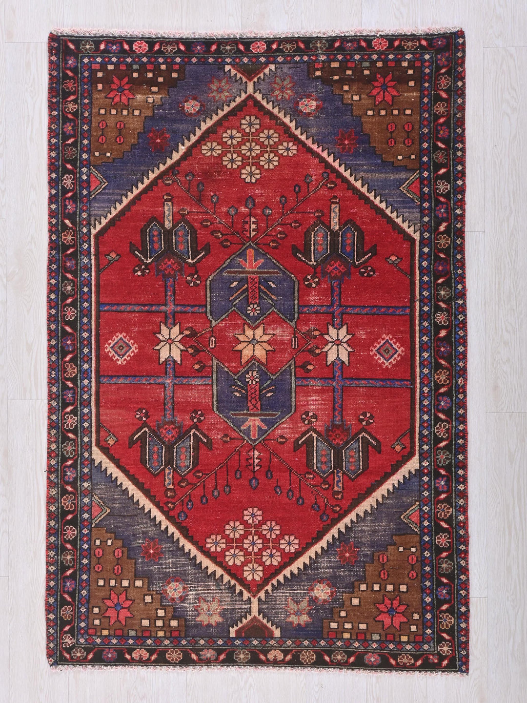 a red and blue rug with a diamond shaped design