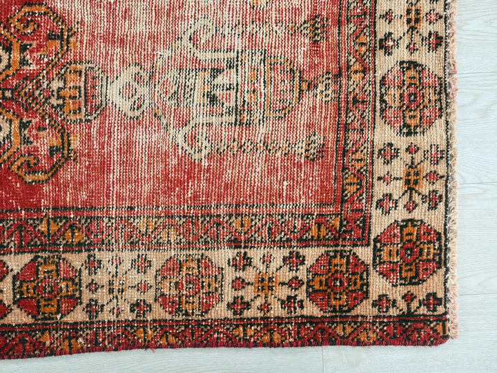 a red rug with a floral design on it