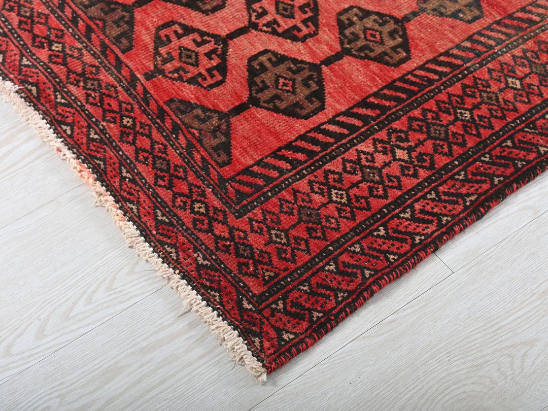a red and black rug on a white floor