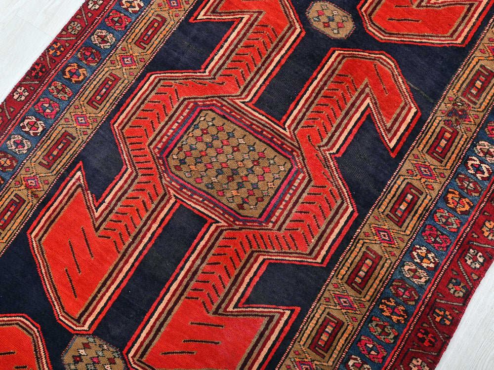 a red and blue oriental rug on a white floor