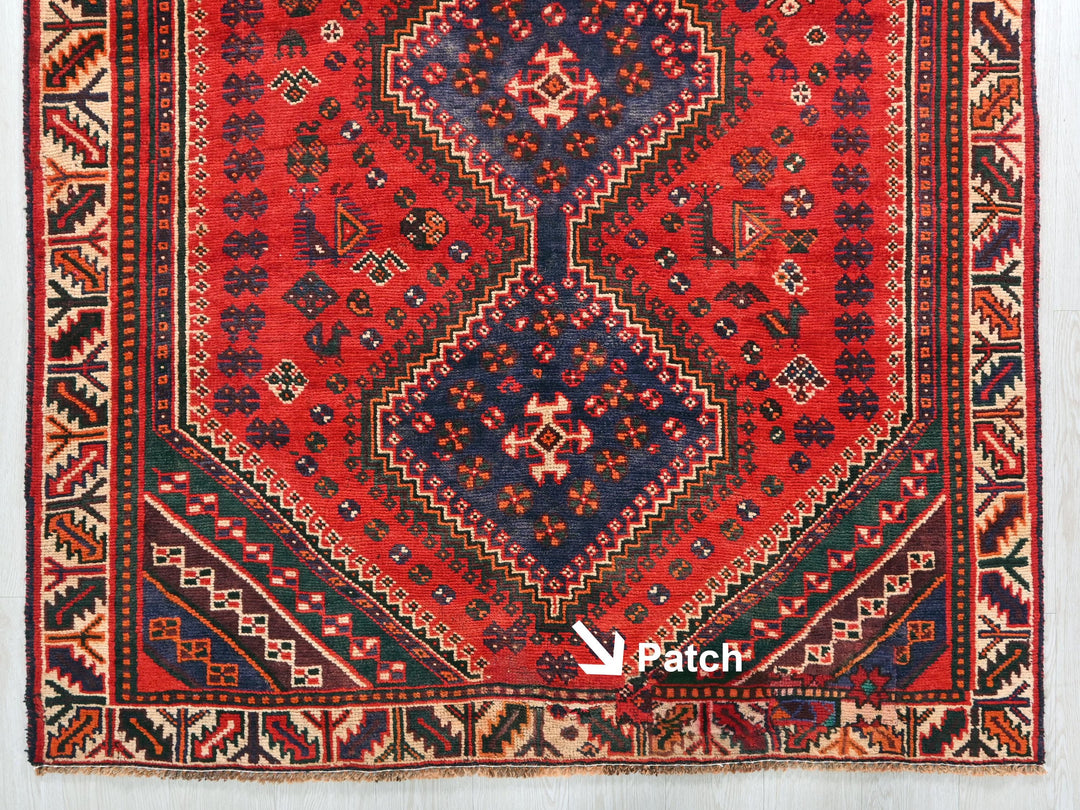 a red rug with a blue and red design