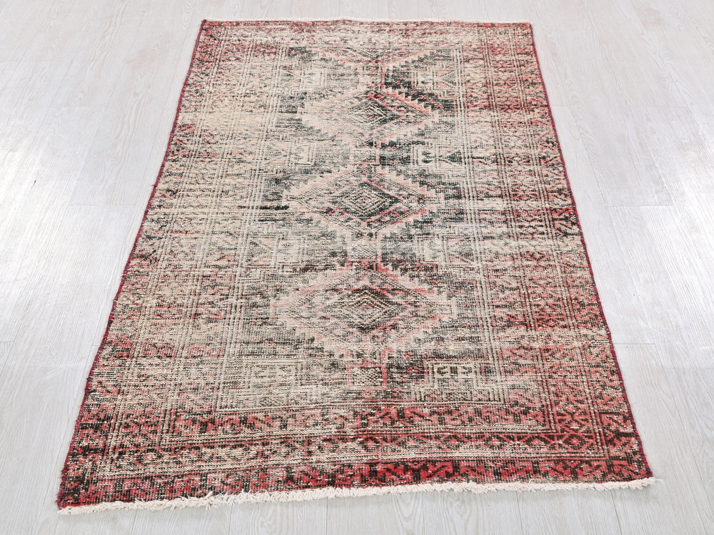 a red and white rug on a wooden floor