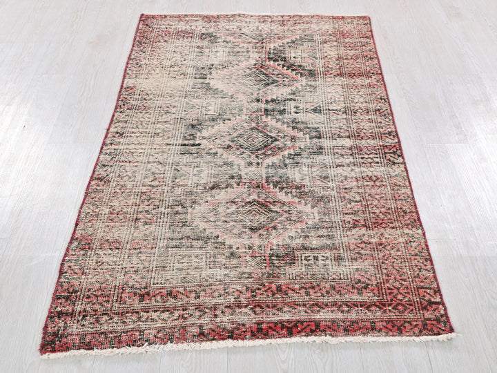 a red and white rug on a wooden floor