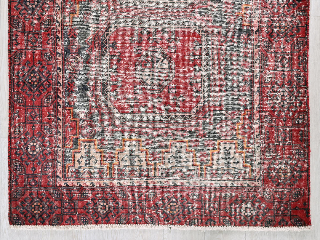 a red rug with a design on the middle of it