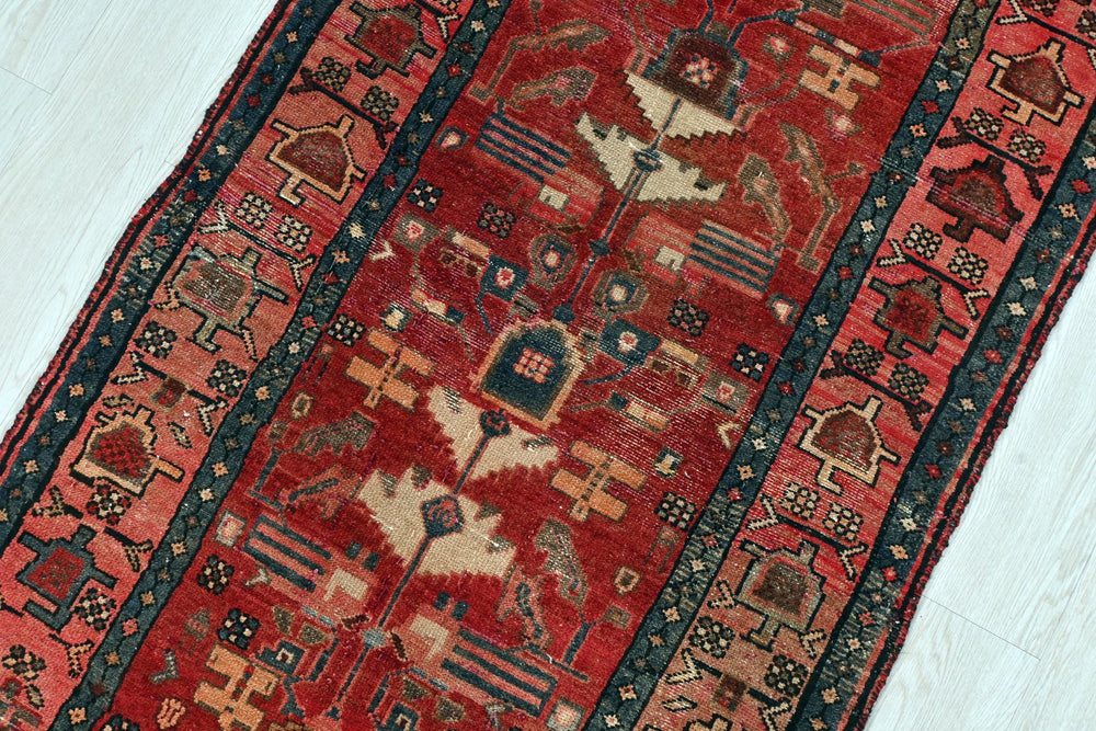 a red rug with a blue border on a white floor