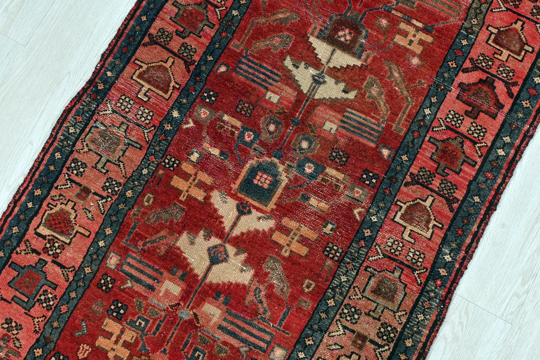a red rug with a blue border on a white floor