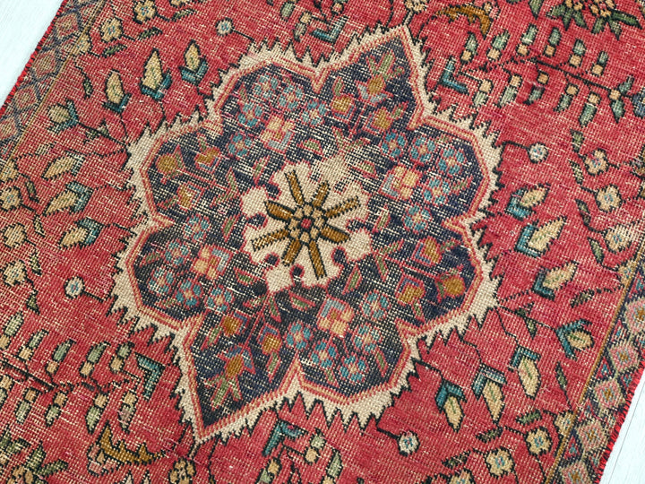 a red oriental rug with a floral design