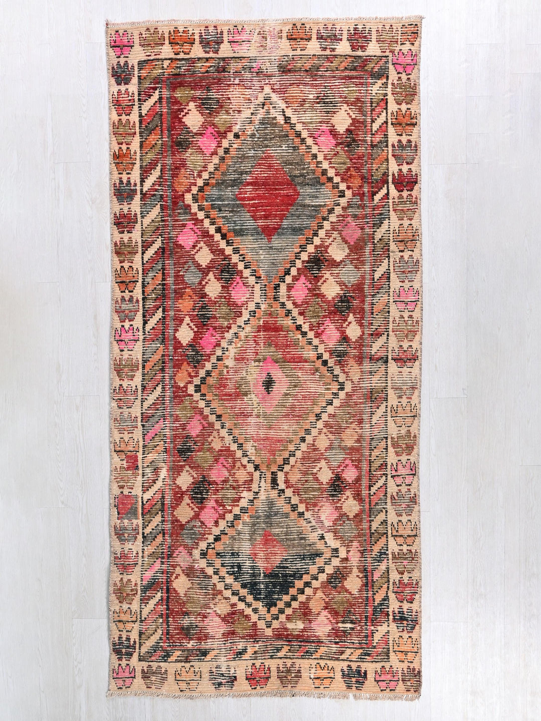 a red, beige, and black rug with a diamond pattern