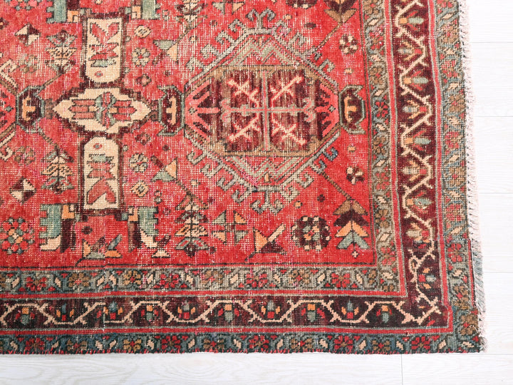 a red rug with a design on the middle of it