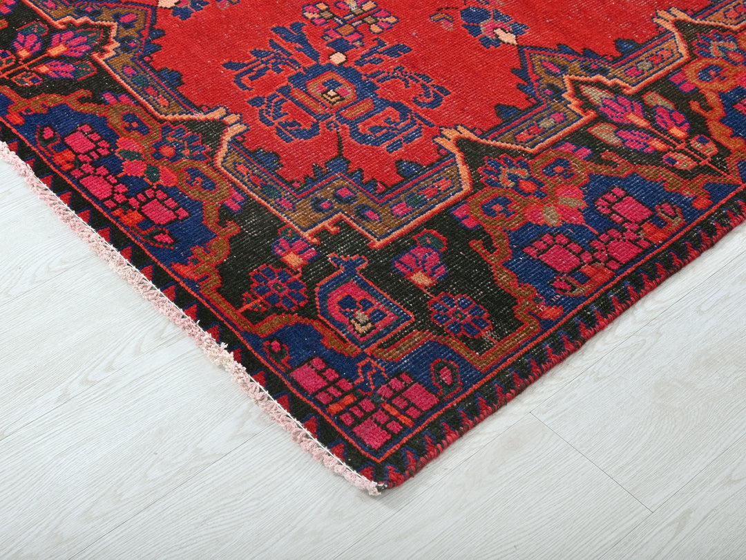 a red and blue oriental rug on a white floor