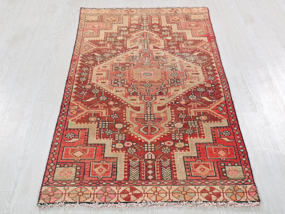 a red rug on a wooden floor with a white floor