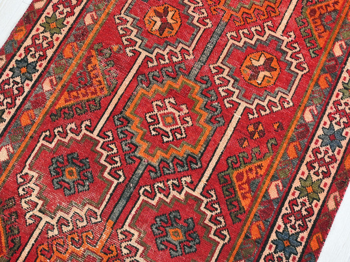 a red rug with a pattern on the middle of it