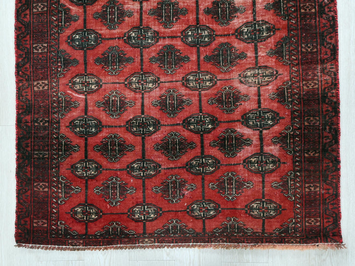 a red rug with a black design on it