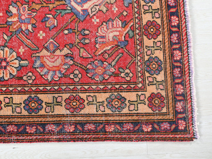 a red rug with a floral design on it