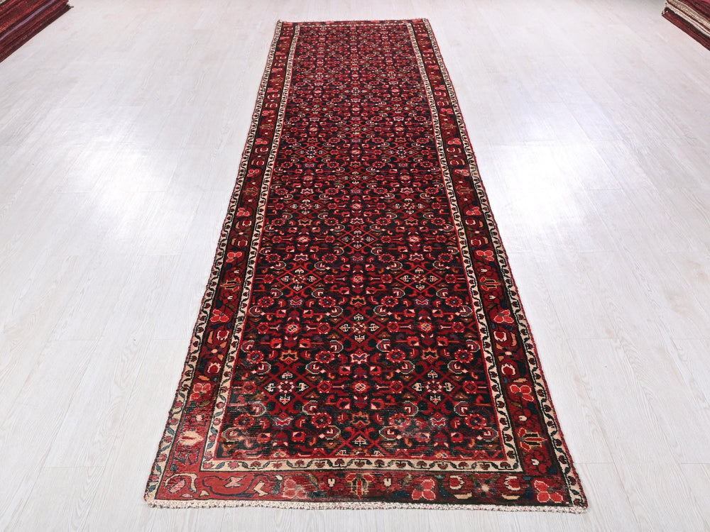 a red and black rug on a white floor