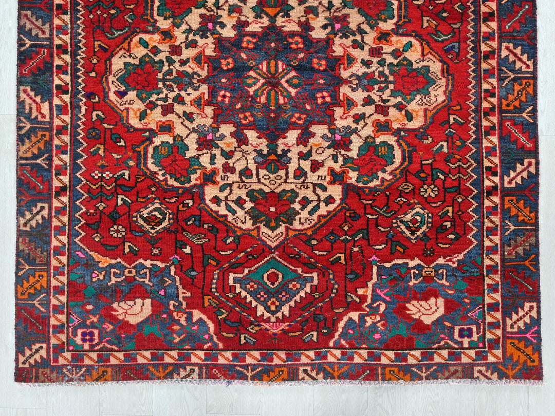 a red and blue rug with an intricate design